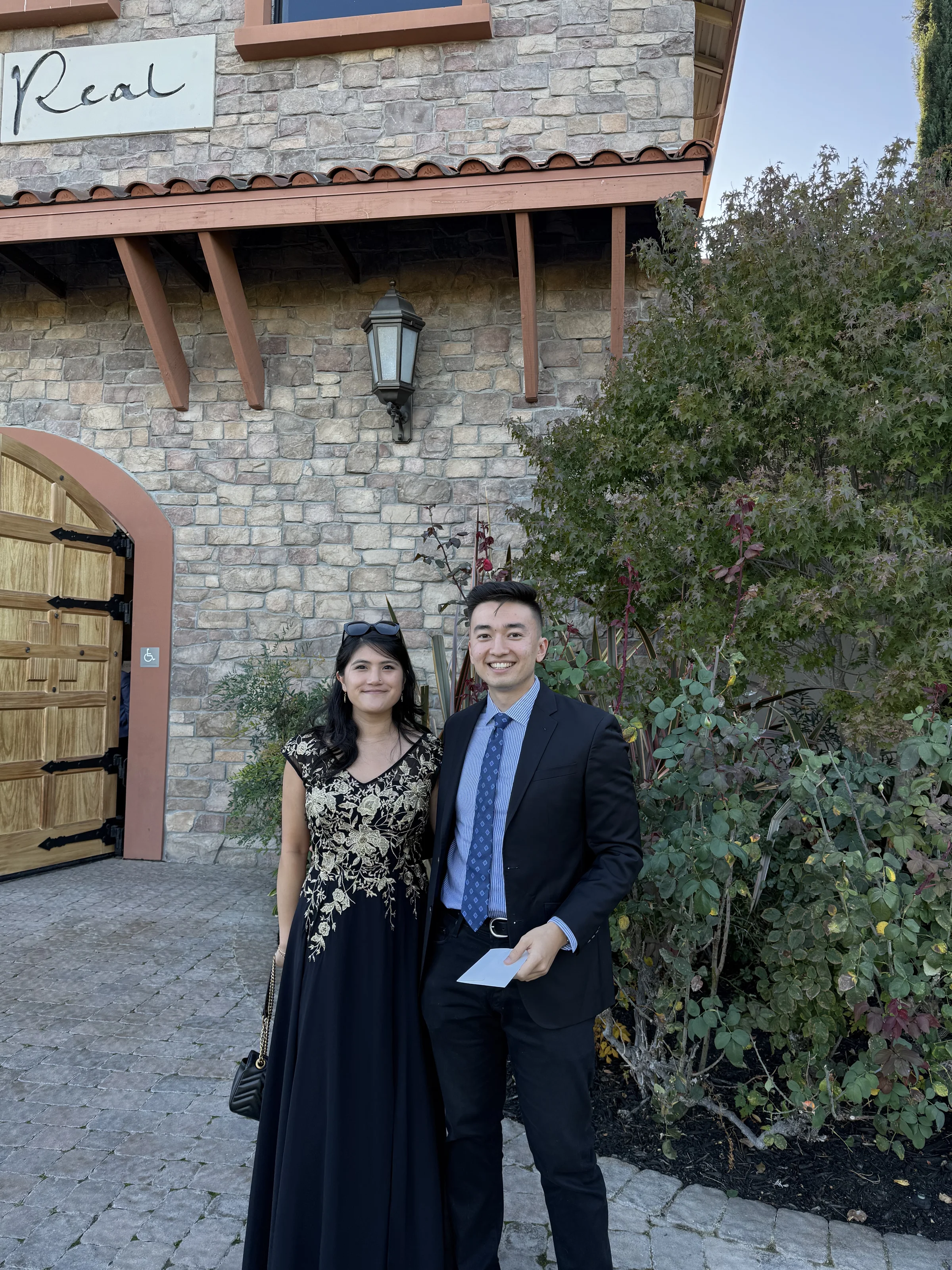 Olivia and Geoff dressed up outside a stone venue