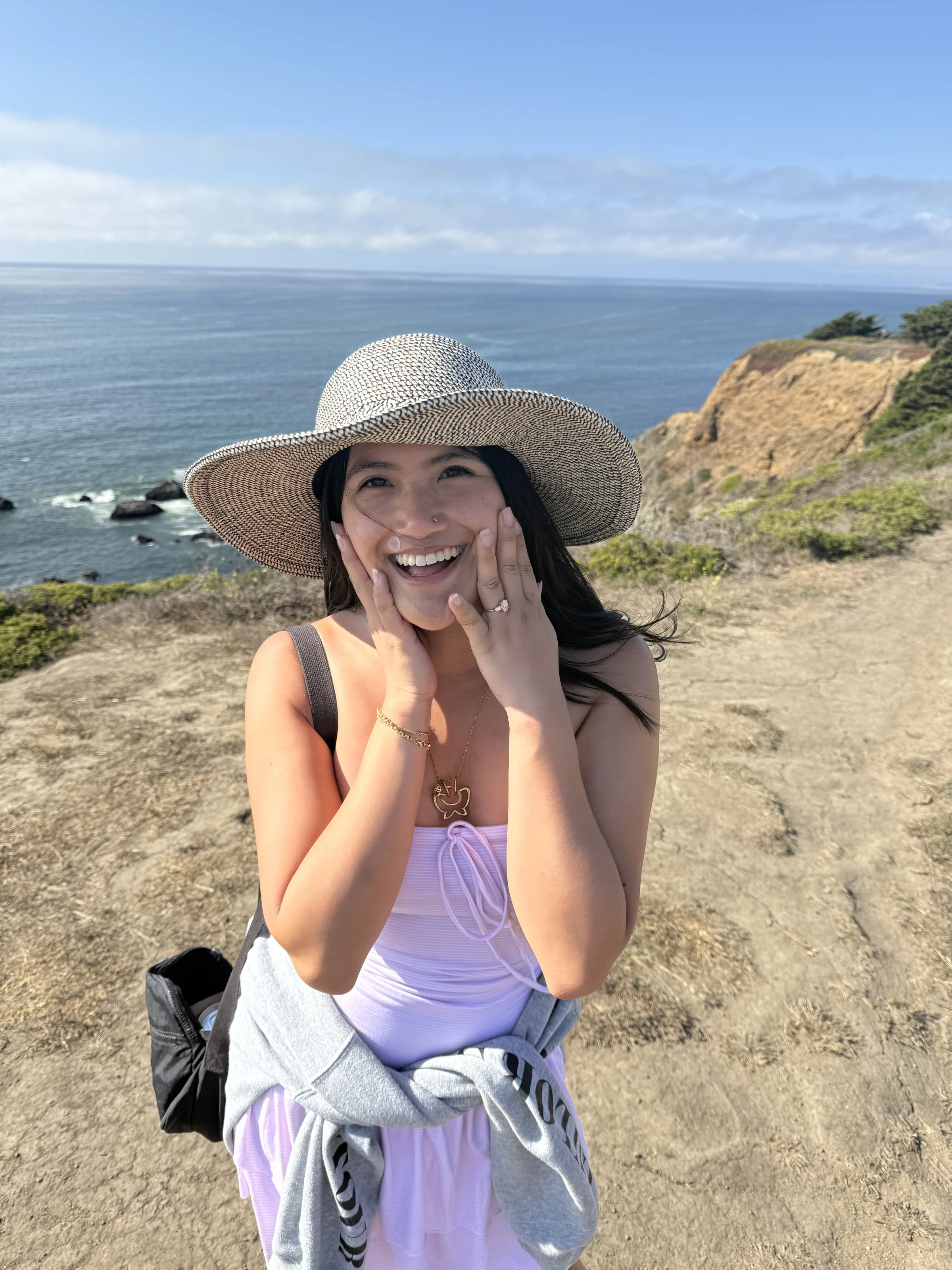 Olivia by the ocean in a wide-brim sun hat